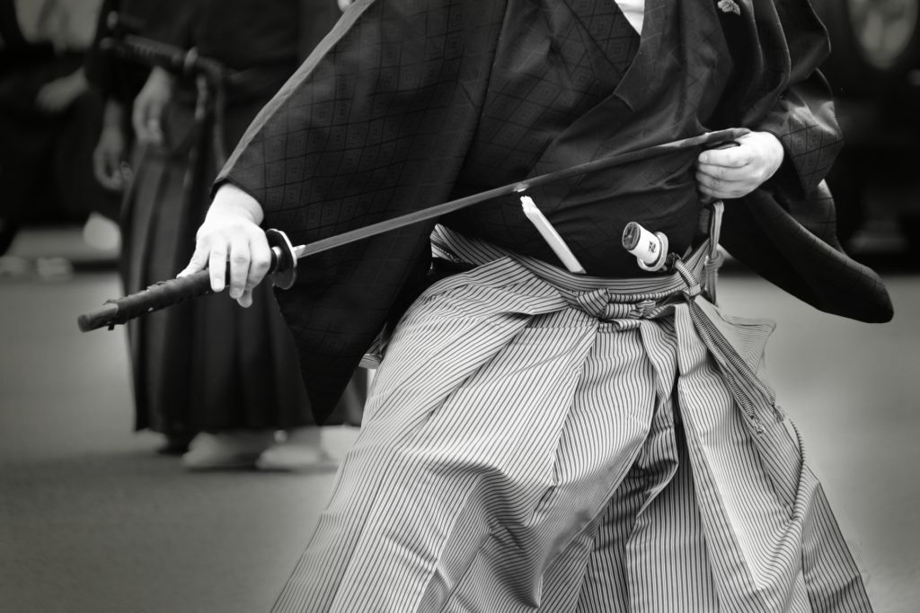 Samurai battling with katana sword in the old days in black and white